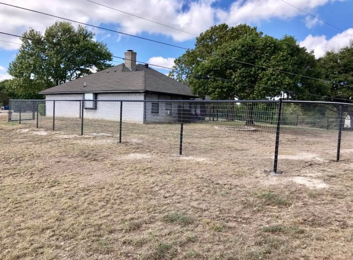 New black wire fence line installed around a brick home